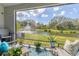 Relaxing screened patio with comfortable seating, potted plants, and scenic pond view with water fountain at 8628 Milestone Dr, Sarasota, FL 34238