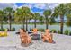 Inviting lakeside fire pit area with Adirondack chairs, creating a cozy space for gatherings and enjoying scenic views at 8916 Isabella Cir, Parrish, FL 34219