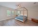 Spacious main bedroom with four-poster bed, hardwood floors and lots of sunlight at 8916 Isabella Cir, Parrish, FL 34219