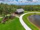 Aerial view of a park with a pond, a pavilion, a walking path, and a seating area at 8916 Isabella Cir, Parrish, FL 34219