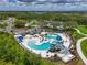 Aerial view of a community pool with a waterslide, palm trees, and lounge chairs at 8916 Isabella Cir, Parrish, FL 34219