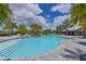 Community pool area featuring palm trees, lounge chairs, and ample space for relaxation and recreation under sunny skies at 8916 Isabella Cir, Parrish, FL 34219
