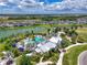 Aerial view of a community pool surrounded by palm trees and cabanas, near homes and a lake at 8916 Isabella Cir, Parrish, FL 34219