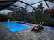 Screened in pool and spa with lounge area and colored LED lighting at dusk at 8916 Isabella Cir, Parrish, FL 34219