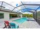 Screened pool and spa with lounge area, outdoor kitchen, and lush landscaping at 8916 Isabella Cir, Parrish, FL 34219