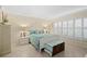 Relaxing bedroom features a white bed and furniture, plantation shutters, and soothing color palette at 1001 Benjamin Franklin Dr # 106, Sarasota, FL 34236