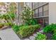 Exterior shot with lush landscaping, stone pathway, and direct access to the property from the outside at 1001 Benjamin Franklin Dr # 106, Sarasota, FL 34236