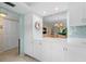Kitchen with white cabinets and countertops, tiled backsplash, view into dining area, and tiled flooring at 1001 Benjamin Franklin Dr # 106, Sarasota, FL 34236
