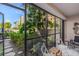 Relaxing lanai space with lush greenery, a garden view, comfortable seating, and tiled flooring at 1001 Benjamin Franklin Dr # 106, Sarasota, FL 34236