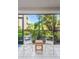 Cozy lanai features white tile flooring, seating, and a beautiful garden view through the screened enclosure at 1001 Benjamin Franklin Dr # 106, Sarasota, FL 34236