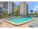 Community pool area with deck chairs, umbrellas, and well maintained landscaping around the pool at 1001 Benjamin Franklin Dr # 106, Sarasota, FL 34236