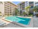 Inviting community pool area with lounge chairs and beautiful landscaping surrounding the cool, clear water at 1001 Benjamin Franklin Dr # 106, Sarasota, FL 34236