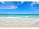 Beautiful beachfront view with gentle waves lapping onto the sandy shore on a sunny day at 105 Casey Key Rd # 20, Nokomis, FL 34275
