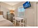 Bedroom featuring a TV, a small table with chairs, and natural light from the window at 105 Casey Key Rd # 20, Nokomis, FL 34275