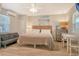 Comfortable bedroom with a queen bed, sofa, dresser, small table, and beach-themed décor at 105 Casey Key Rd # 20, Nokomis, FL 34275