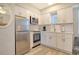Well-equipped kitchenette featuring stainless steel appliances, white cabinets, and a cozy seating area at 105 Casey Key Rd # 20, Nokomis, FL 34275