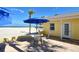 Outdoor patio area with brick pavers, seating, an umbrella, and a scenic beach backdrop at 105 Casey Key Rd # 20, Nokomis, FL 34275
