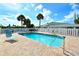 Inviting community pool surrounded by a brick deck, white fence, and lush tropical landscaping at 105 Casey Key Rd # 20, Nokomis, FL 34275