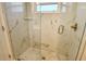 Modern glass shower featuring white marble tiling, bronze fixtures, and stone pebble floor at 105 Casey Key Rd # 20, Nokomis, FL 34275