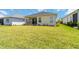 Spacious backyard featuring a well-maintained lawn, covered patio, and freshly landscaped areas at 10926 Sand Pine Ln, Parrish, FL 34219