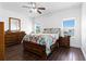 Bedroom featuring hard surface floors, a ceiling fan, and bright sunny windows at 10926 Sand Pine Ln, Parrish, FL 34219