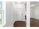 Clean, bright foyer featuring wood-look tile flooring and a freshly painted white front door at 10926 Sand Pine Ln, Parrish, FL 34219