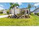 Charming home with a well-manicured lawn, lush landscaping, and inviting front entrance at 10926 Sand Pine Ln, Parrish, FL 34219