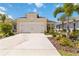 A well-maintained two-car garage situated on a concrete driveway amidst landscaped surroundings at 10926 Sand Pine Ln, Parrish, FL 34219