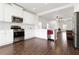Bright kitchen featuring white cabinets, stainless steel appliances, and wood-look tile flooring at 10926 Sand Pine Ln, Parrish, FL 34219