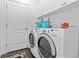 Well-lit laundry room with modern washer and dryer, storage, and white cabinets at 10926 Sand Pine Ln, Parrish, FL 34219