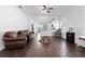 Well-lit living space showcasing the open layout to the kitchen, enhanced by wood-look tile at 10926 Sand Pine Ln, Parrish, FL 34219