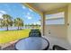 Covered patio features an outdoor table with tranquil views of the lake and lush landscaping at 10926 Sand Pine Ln, Parrish, FL 34219