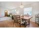 Open-concept dining room with hardwood floors, a modern chandelier, and views of the living area at 110 San Lorenzo Ct, Bradenton, FL 34208