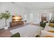 Bright living room with hardwood floors, white sofa, view of hallway and front door, and a stylish media center at 110 San Lorenzo Ct, Bradenton, FL 34208