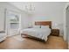 Bright main bedroom featuring a window, a modern chandelier, and wood-look floors at 110 San Lorenzo Ct, Bradenton, FL 34208