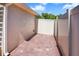 Side patio with brick floor and white fence under a bright blue sky provides privacy and charm at 110 San Lorenzo Ct, Bradenton, FL 34208