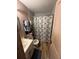 A functional bathroom featuring a vanity, toilet, and shower with a patterned curtain at 1113 23Rd W Ave, Bradenton, FL 34205
