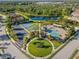 Aerial view featuring a community clubhouse, pool, playground, tennis courts, and lush landscaping at 11410 57Th E St, Parrish, FL 34219