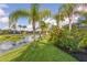 Tranquil backyard view featuring a lake, lush landscaping, and palm trees on a bright sunny day at 11410 57Th E St, Parrish, FL 34219