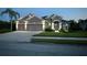 Beautiful one-story home showcasing manicured lawn and a gray exterior, complemented by a three-car garage at 11410 57Th E St, Parrish, FL 34219