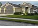 Beautiful one-story home showcasing manicured lawn and a gray exterior, complemented by a three-car garage at 11410 57Th E St, Parrish, FL 34219