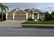 Beautiful one-story home showcasing manicured lawn and a gray exterior, complemented by a three-car garage at 11410 57Th E St, Parrish, FL 34219