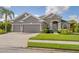 Stunning single-story home showcasing a two-car garage, lush green lawn, and impeccable landscaping at 11410 57Th E St, Parrish, FL 34219