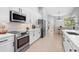 Bright kitchen boasts white cabinets, stainless steel appliances, and ample counter space at 11410 57Th E St, Parrish, FL 34219