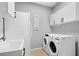 Functional laundry room with a sink, modern washer and dryer, and ample storage space at 11410 57Th E St, Parrish, FL 34219