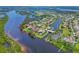 Breathtaking aerial view of a waterfront property with a private dock, surrounded by lush greenery and serene waterways at 11807 Rive Isle Run, Parrish, FL 34219