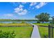 Beautiful waterfront backyard with lush green grass and a long wooden dock on the river at 11807 Rive Isle Run, Parrish, FL 34219