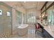 Modern bathroom with a soaking tub, glass-enclosed shower, double vanity, and elegant fixtures at 11807 Rive Isle Run, Parrish, FL 34219
