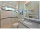 Modern bathroom features a glass enclosed shower with tile surround and a large mirror over the vanity at 11807 Rive Isle Run, Parrish, FL 34219