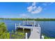 View of the boat dock on the water with a boat lift at 11807 Rive Isle Run, Parrish, FL 34219